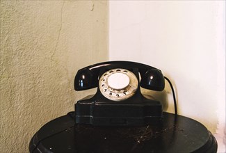 Retro landline telephone on table in corner