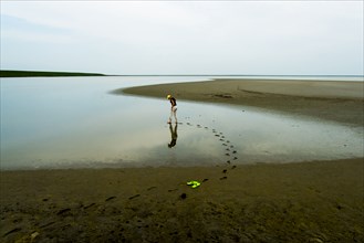 Footprints of woman wading at beach