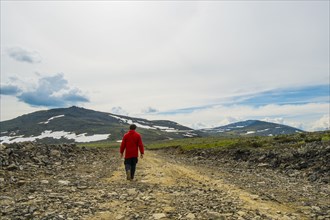 Man walking on mountain path in winter