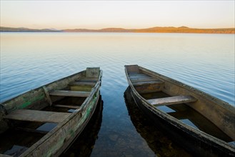 Two rowboats on lake at sunset
