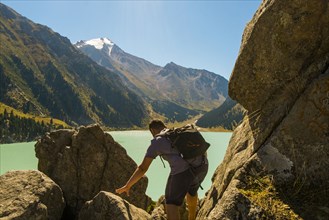 Caucasian man backpacking near mountain lake