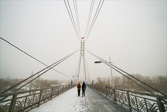 Caucasian women crossing bridge in winter