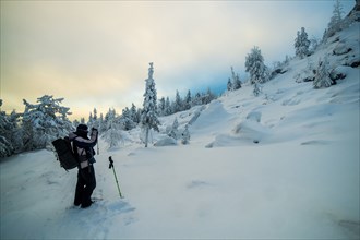 Caucasian man photographing snowy mountain