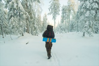 Caucasian man hiking in snowy forest