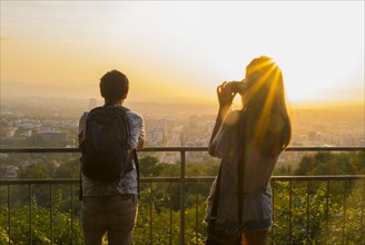 Caucasian couple photographing scenic view of cityscape