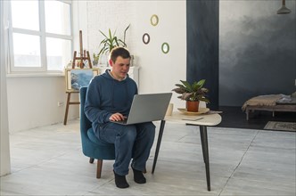 Caucasian man sitting in chair using laptop