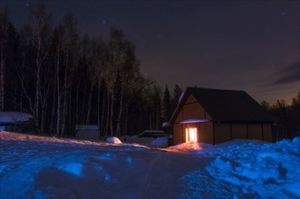 Light glowing in remote cabin in winter