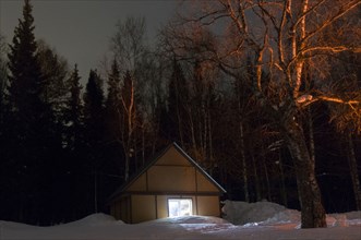 Light glowing in remote cabin in winter