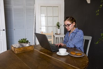 Caucasian woman sitting at table using laptop