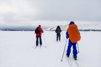 Caucasian people cross-country skiing in field