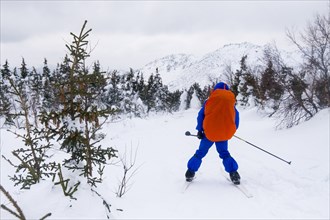 Caucasian man cross-country skiing near mountain