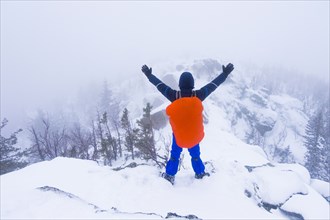 Caucasian hiker waving on snow covered mountain