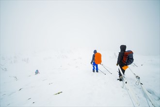 Caucasian hikers carrying skis on mountain