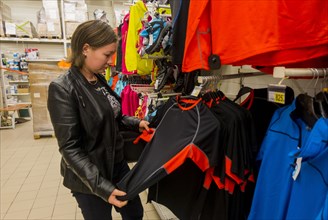 Caucasian woman examining shirt in store