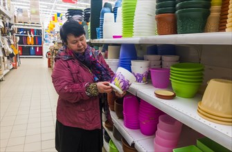 Caucasian woman examining pot in store