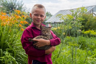 Caucasian boy holding cat on farm