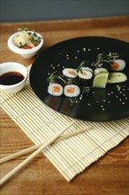 Chopsticks and sushi with sauce