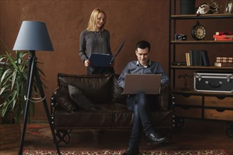 Middle Eastern couple using laptop in livingroom