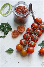 Tomatoes on vine near jar