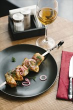 Meat on skewer with onions and white wine