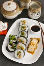 Sushi on plate with sauce and chopsticks