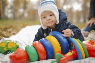 Middle Eastern baby boy playing with toys in park