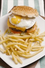 Cheeseburger with egg and french fries