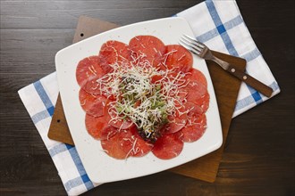 Grated cheese on plate of sliced meat