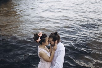 Middle Eastern couple embracing near water
