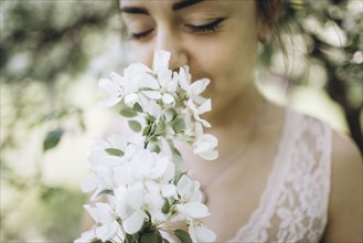 Middle Eastern woman smelling flowers