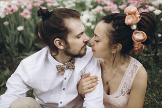 Middle Eastern couple hugging near flowers
