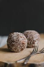 Chocolate balls with forks on cutting board