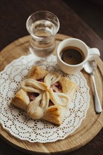 Pastry on the doily with espresso