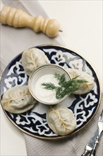 Dumplings and sauce on plate with fork and knife