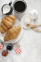 Croissants on plate with coffee and jam