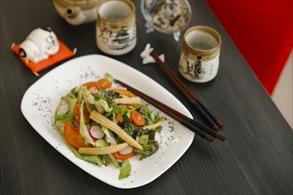 Chopsticks on the plate of salad
