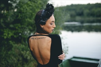 Middle Eastern woman wearing black dress in boat on lake