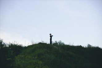 Middle Eastern woman wearing black dress on hill