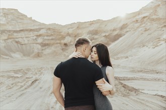 Middle Eastern couple hugging in desert