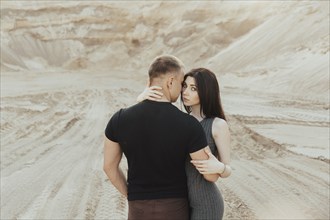 Middle Eastern couple hugging in desert