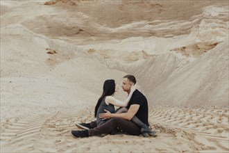 Middle Eastern couple cuddling in desert