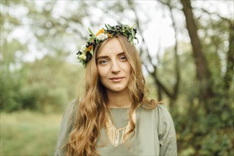 Middle Eastern woman wearing flower crown in woods