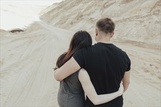 Middle Eastern couple hugging in the desert