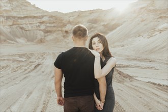 Middle Eastern couple hugging in the desert