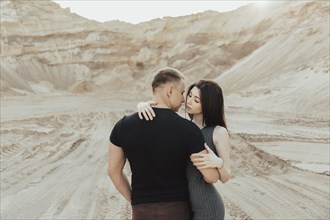Middle Eastern couple kissing in the desert