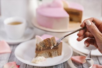 Hand of woman holding cake on fork