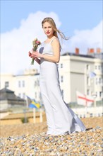 Woman holding bouquet on beach