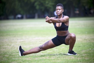Black athlete stretching in park