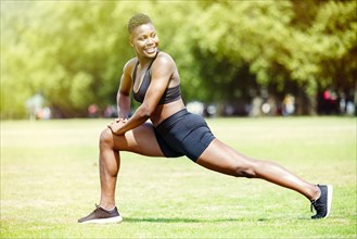 Black athlete stretching in park