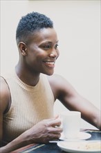 Black woman drinking coffee in cafe